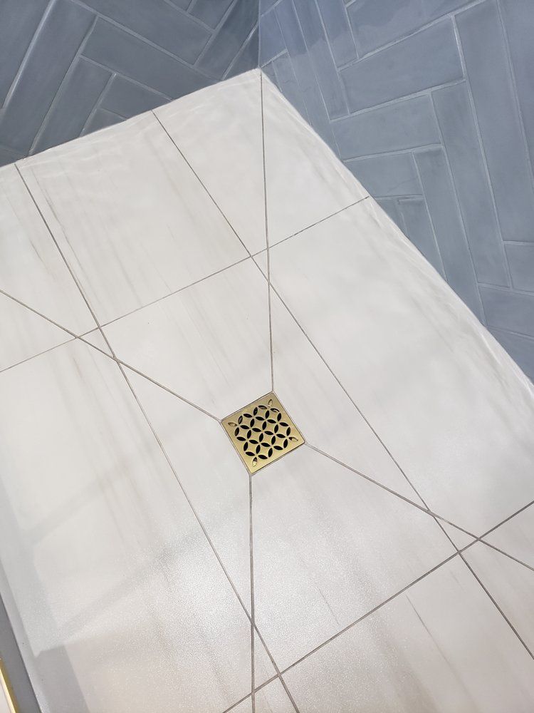 Modern shower floor with light grey tiles installed in Sherwood Park by XMP Construction.