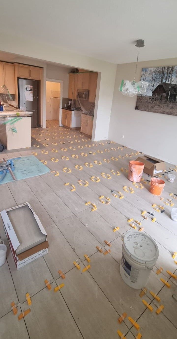 Installation of large light beige floor tiles in a Sherwood Park home by XMP Construction.