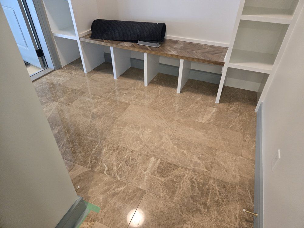 Beautiful light brown marble-look tile flooring in a Sherwood Park entryway by XMP Construction.