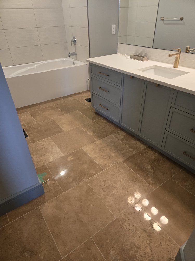 Light brown stone tiled bathroom floor in Sherwood Park by XMP Construction.