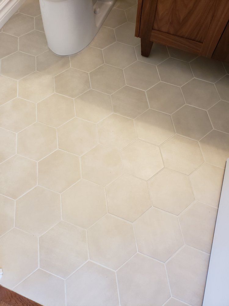 Light beige hexagonal tile flooring in a Sherwood Park bathroom by XMP Construction.