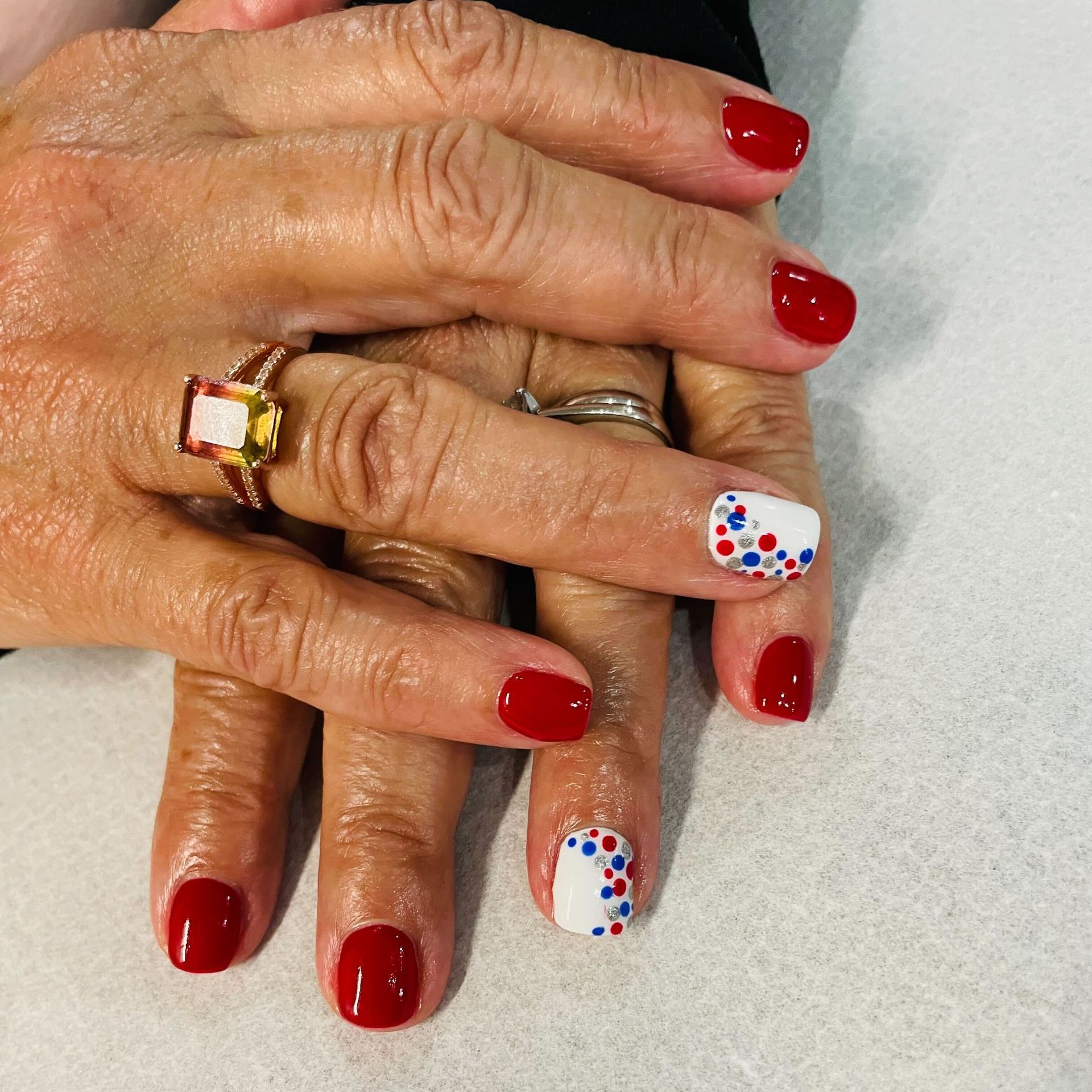 a woman 's nails are painted red white and blue