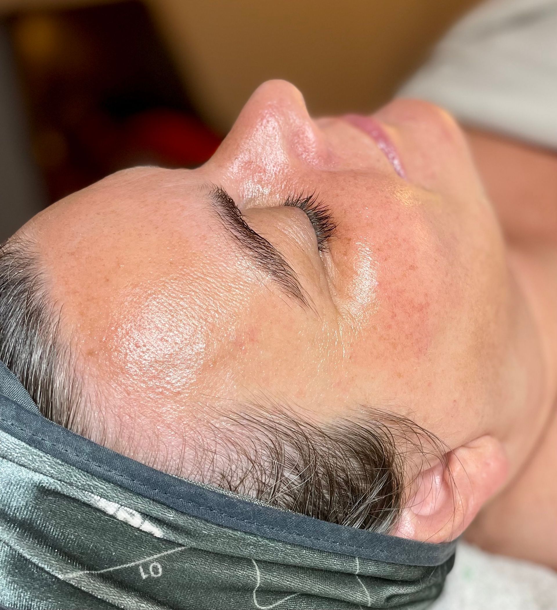 a woman wearing a headband getting a facial