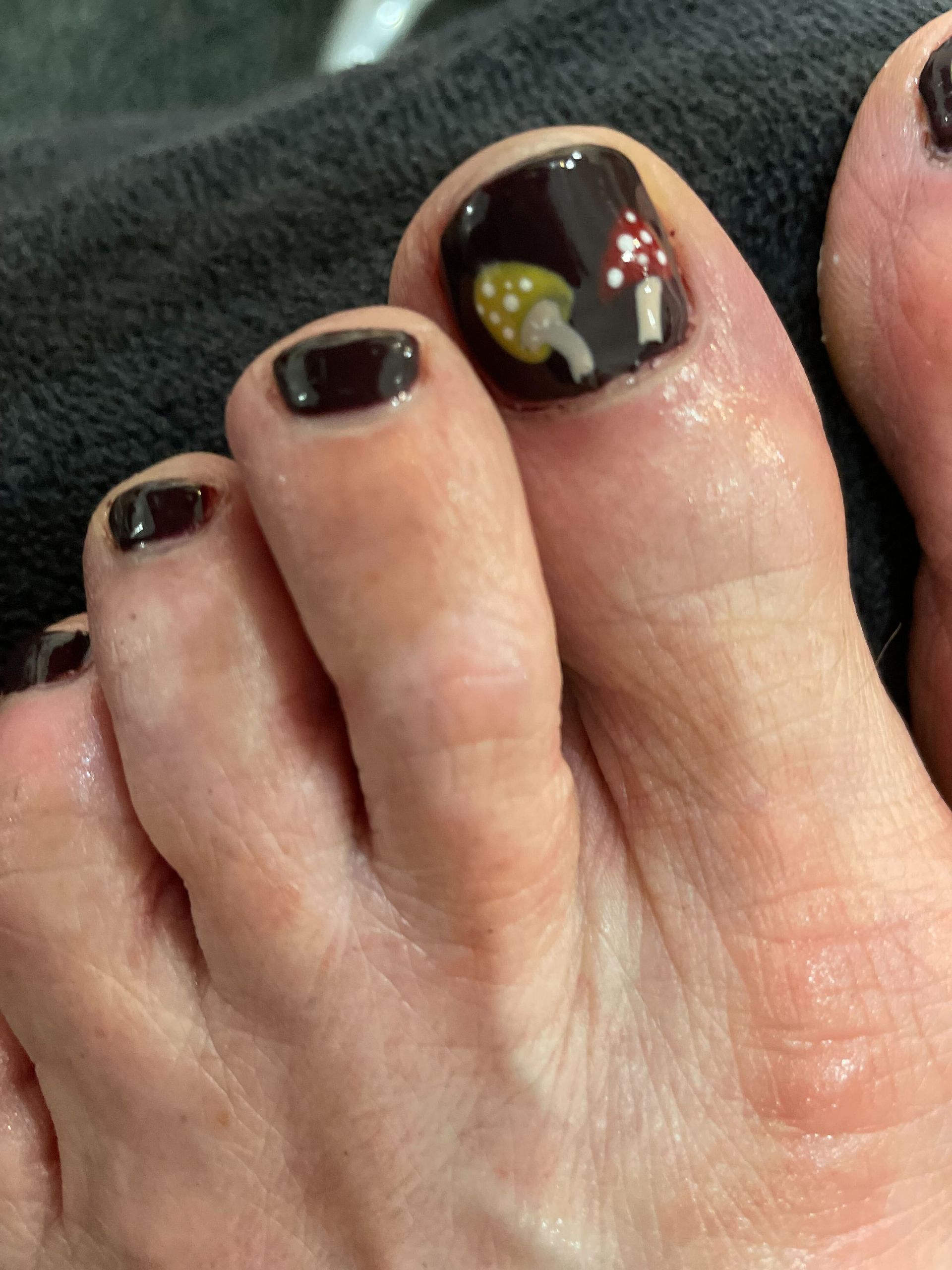 a close up of a person 's toenails with mushrooms painted on them