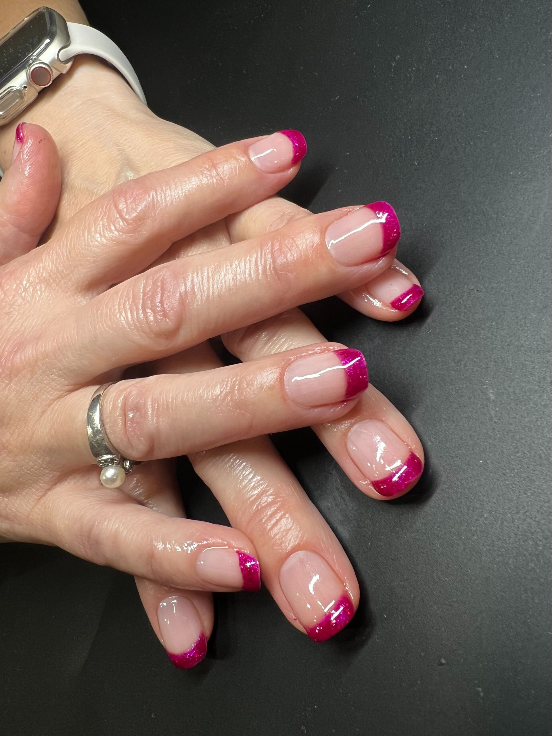 a close up of a woman 's nails with a watch on her wrist