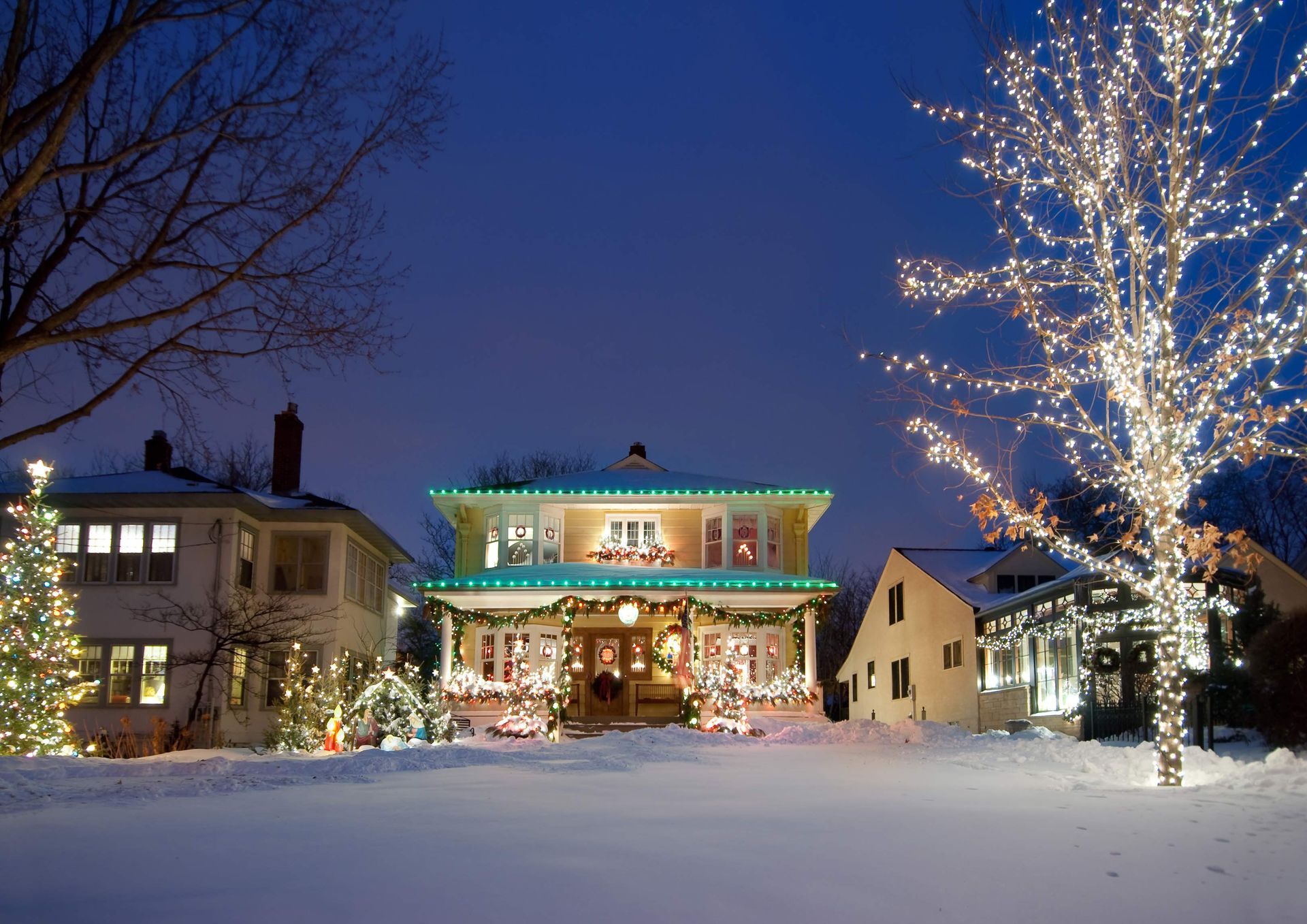 A house is decorated with christmas lights in the snow