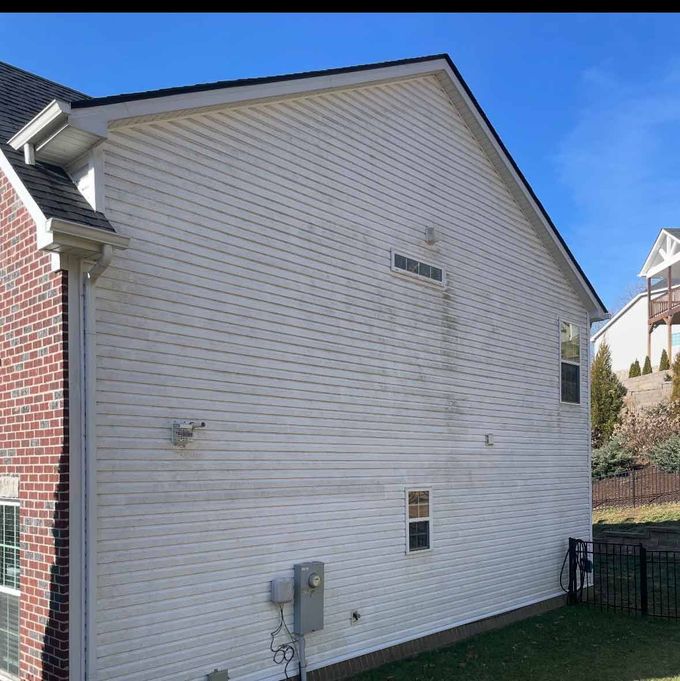 A white house with a brick side and a blue sky in the background
