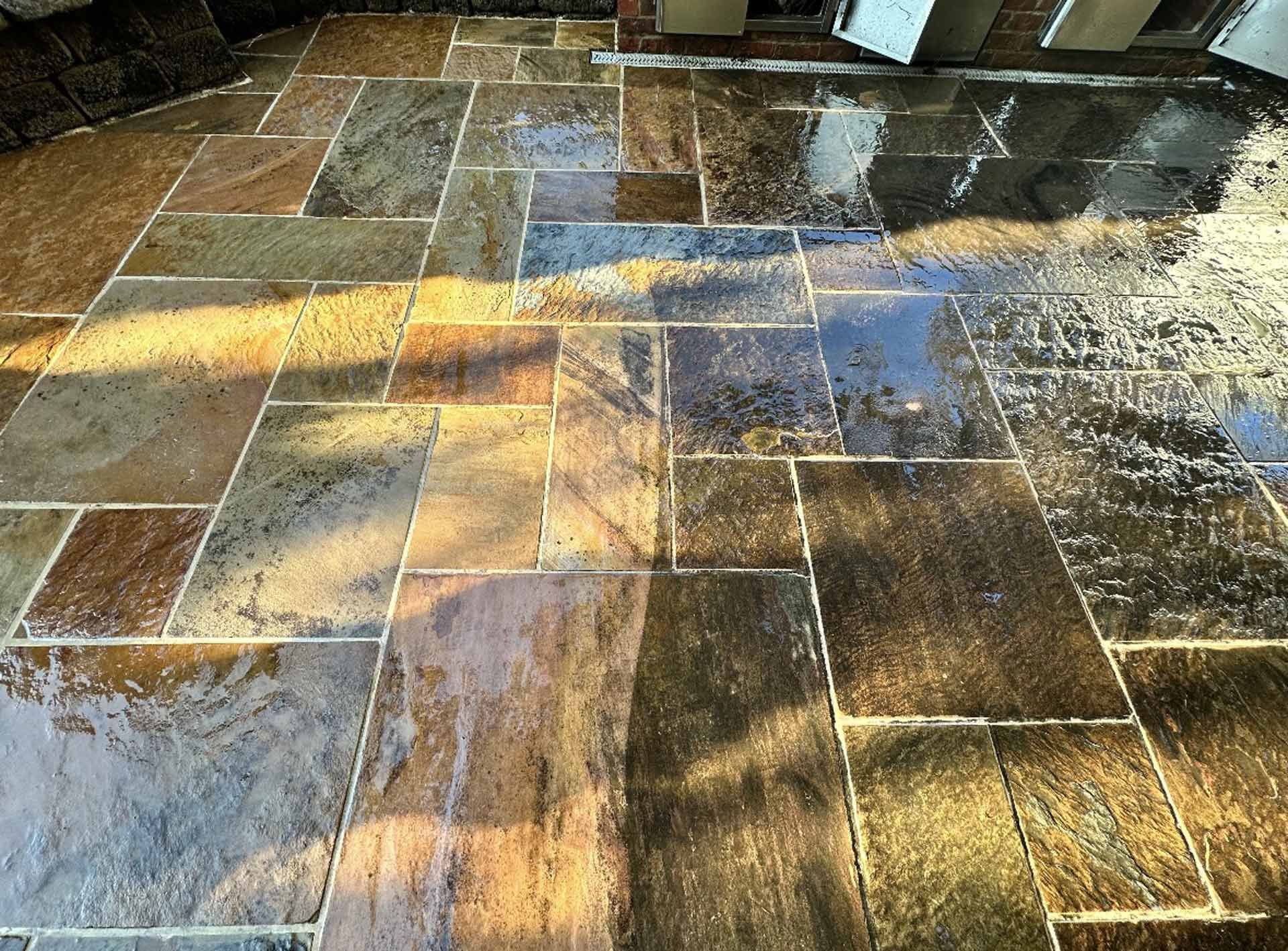 A close up of a tiled floor with a brick wall in the background.