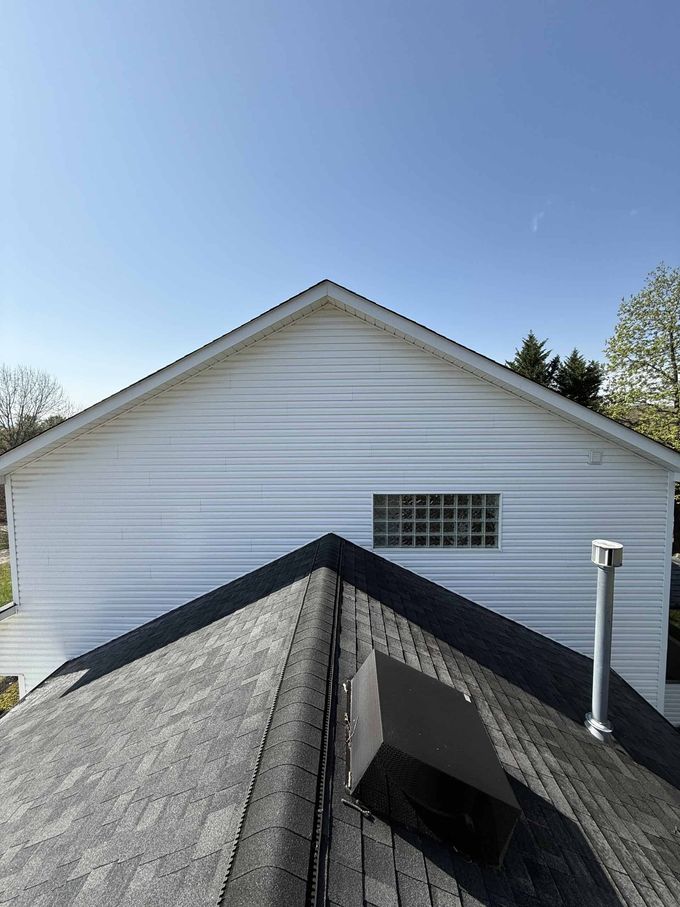 A white house with a black roof and a window
