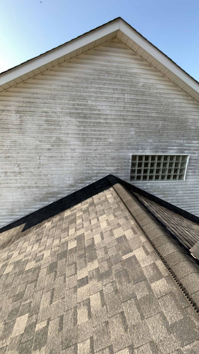 A white house with a roof and a window.