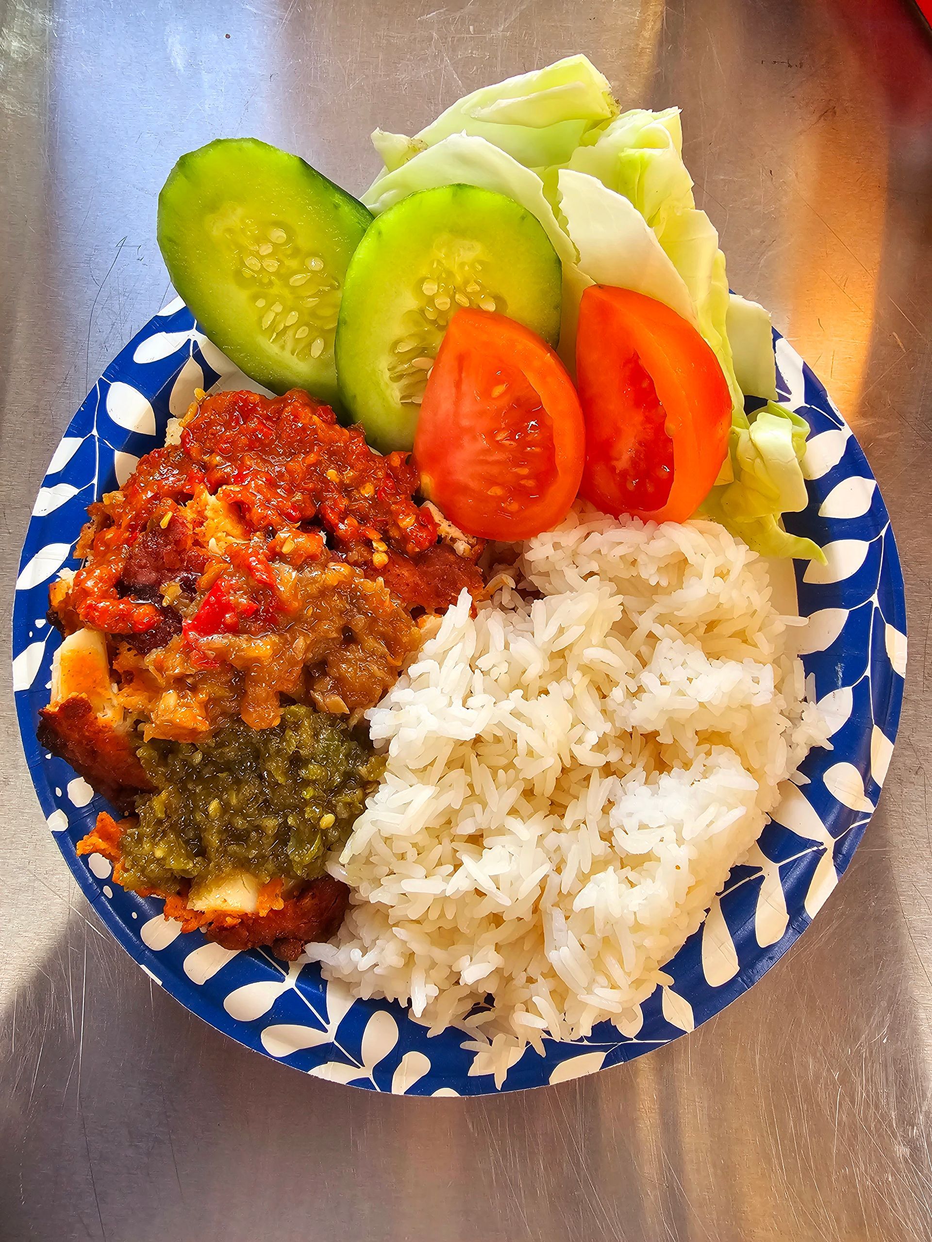 Red hot sambal covered chicken with white rice and fresh veggies