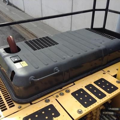 A yellow and black tractor with a large black container on top of it