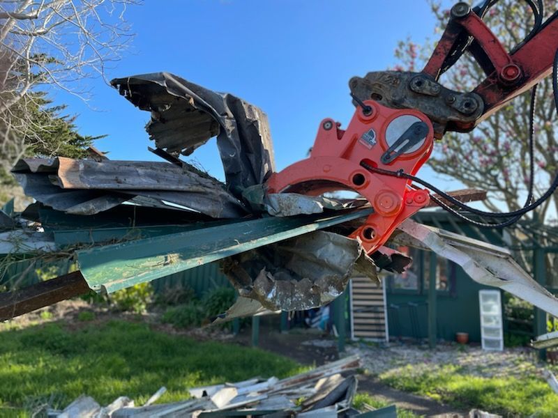 A large piece of metal is being lifted by a crane.