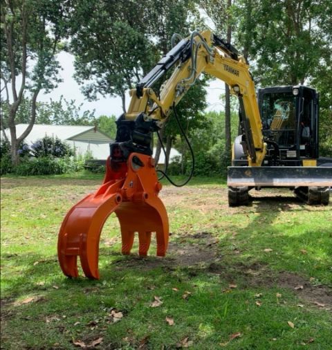 A large orange claw is attached to a yellow excavator.