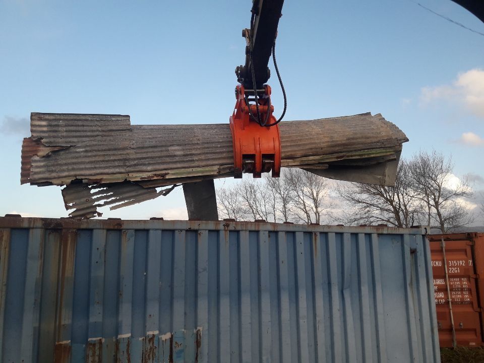 A large piece of wood is being lifted by a crane