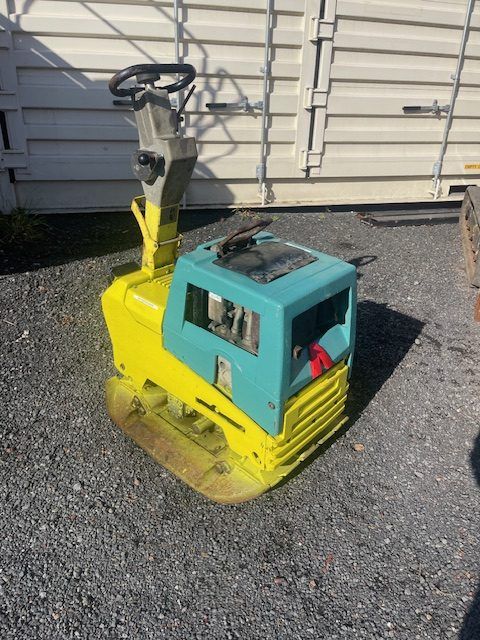 A yellow and blue machine is sitting on the ground.