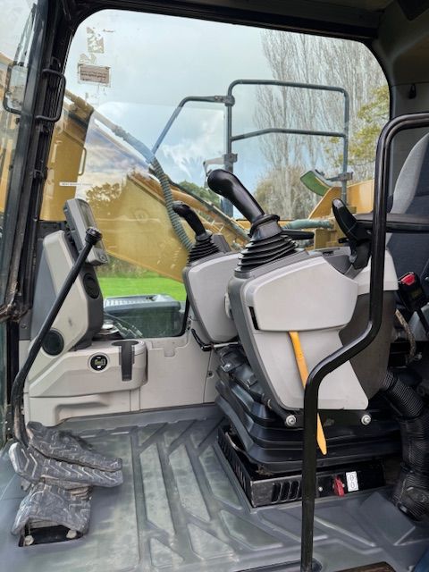 The inside of a construction vehicle with a lot of seats and controls