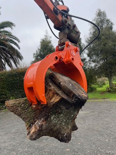 A large piece of wood is being lifted by a crane