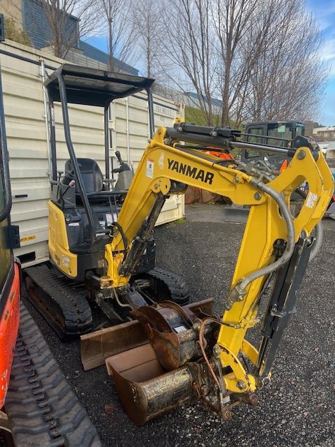 A yellow yanmar excavator is parked in a parking lot.