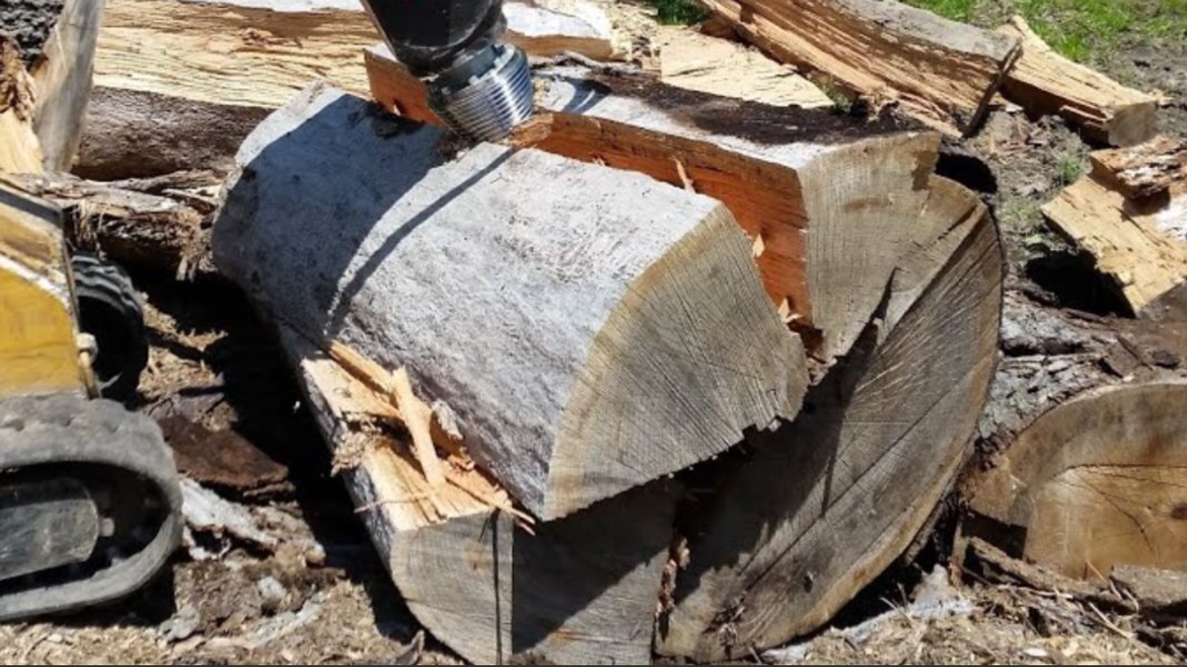 A person is cutting a large piece of wood with a chainsaw.