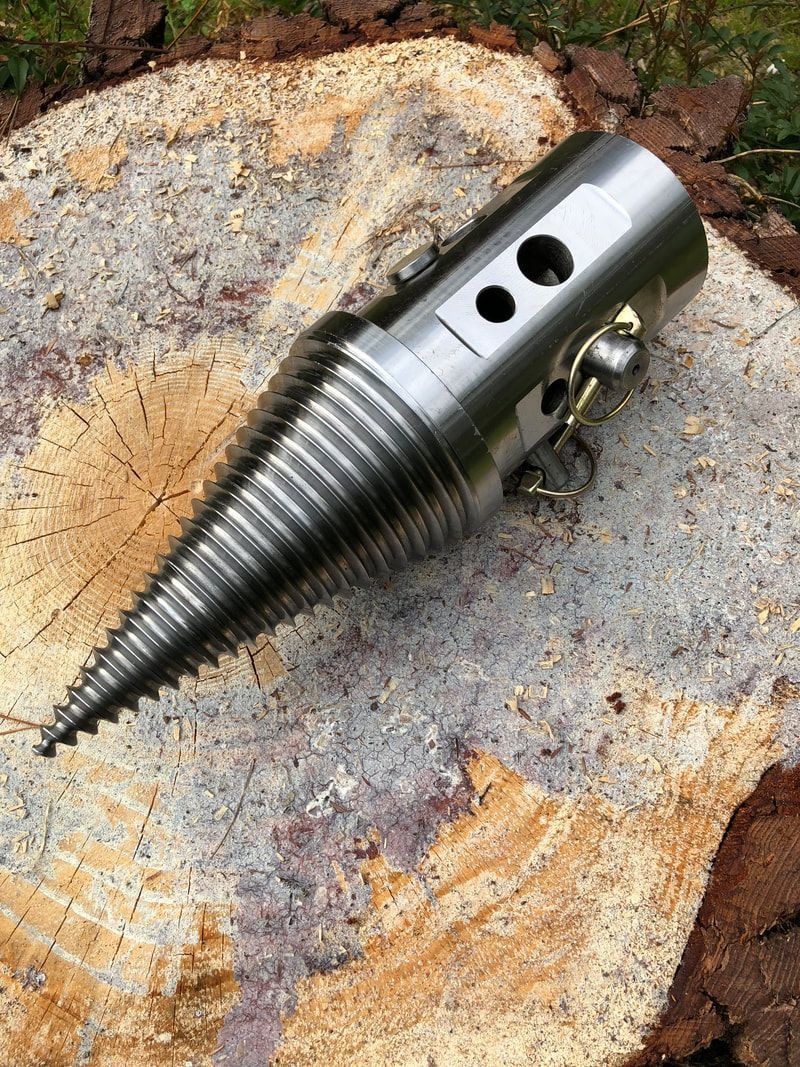 A metal object is sitting on top of a tree stump.