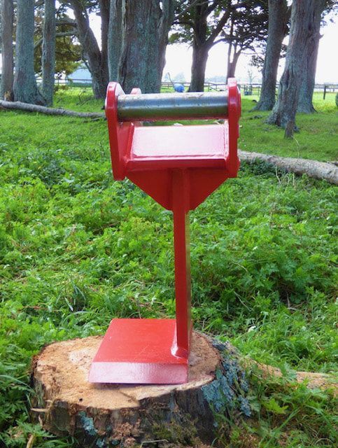 A red object is sitting on top of a tree stump.
