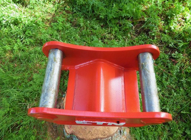 A red object is sitting on top of a stump in the grass.