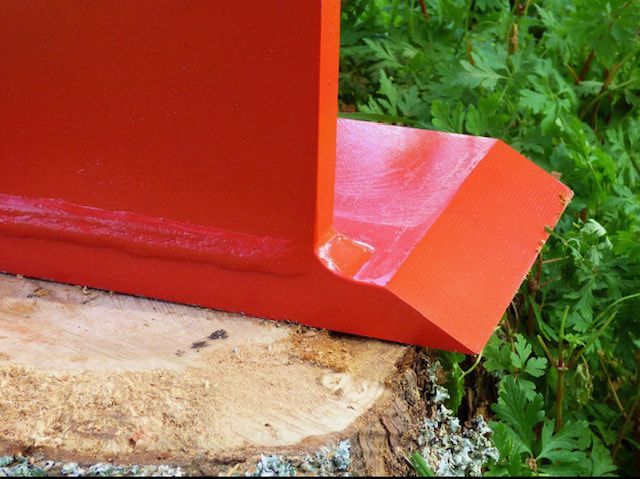 A red object is sitting on top of a tree stump