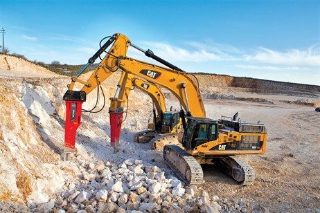 A bulldozer is breaking rocks in a quarry.