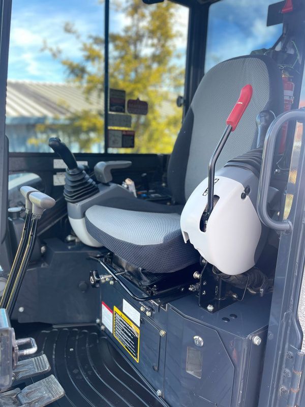 The inside of a tractor with a seat and controls