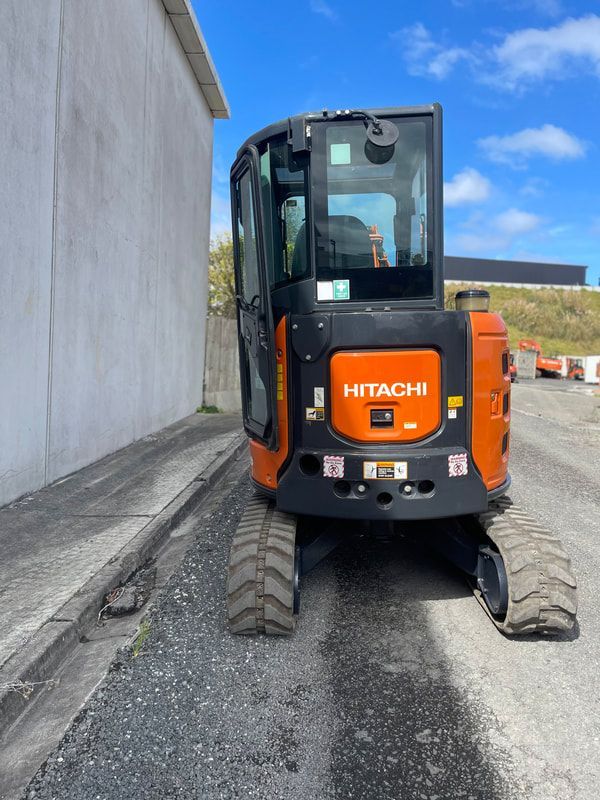 A hitachi excavator is parked on the side of the road