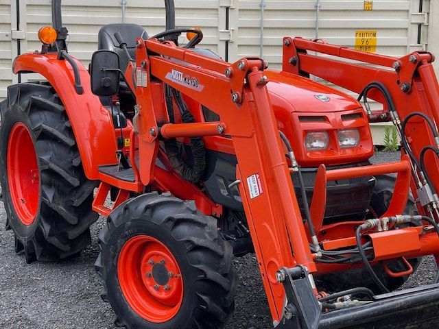 A red tractor with a front loader attached to it