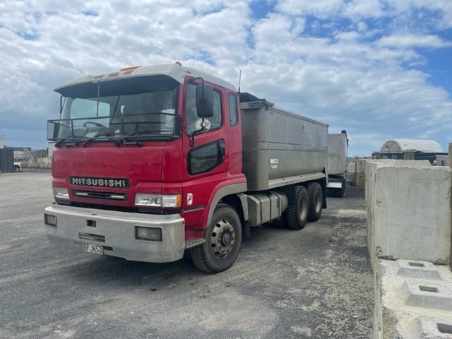 A red mitsubishi dump truck is parked in a parking lot