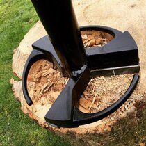 A black object is sitting on top of a tree stump.