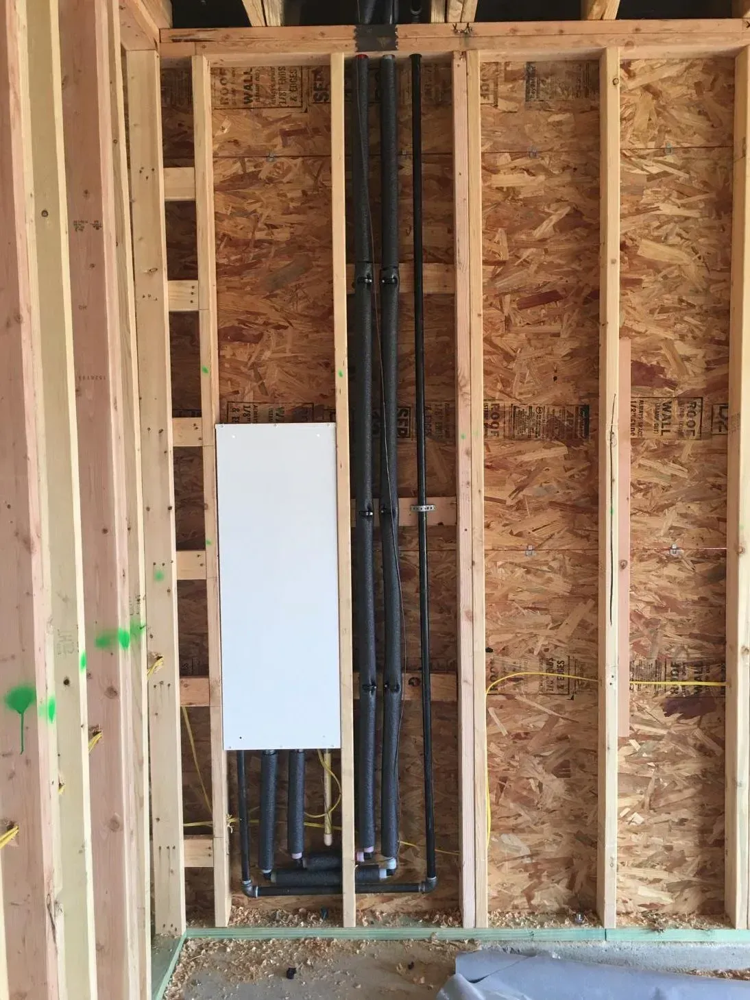 A wooden wall with pipes coming out of it.