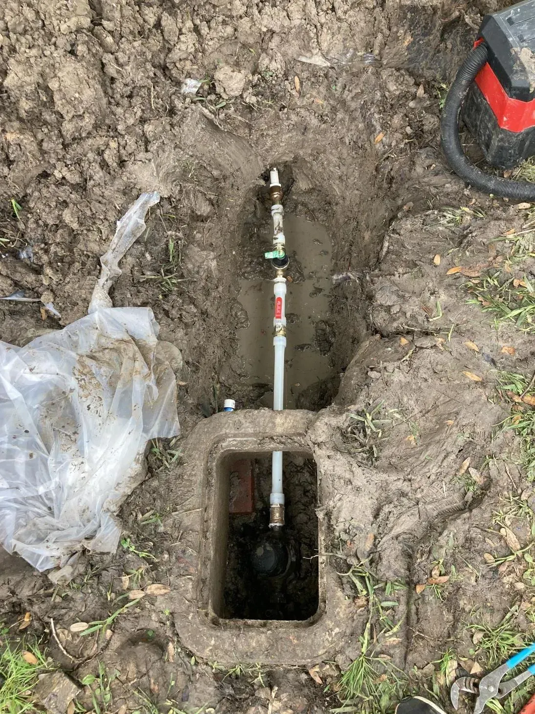 A pipe is coming out of a hole in the ground.