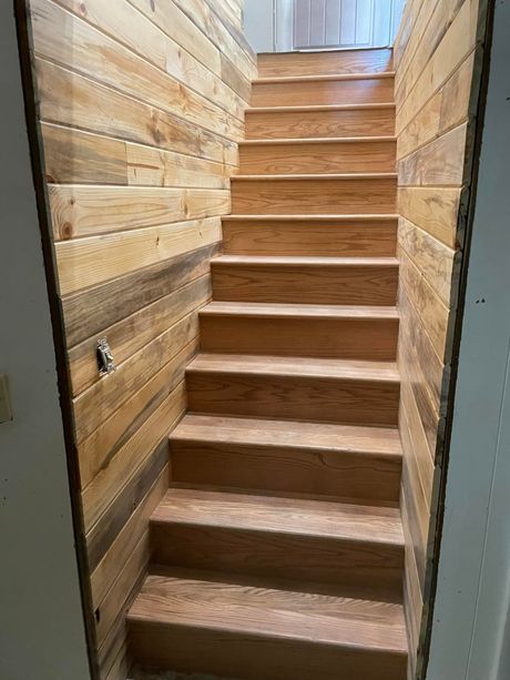 A set of wooden stairs leading up to the second floor of a house.