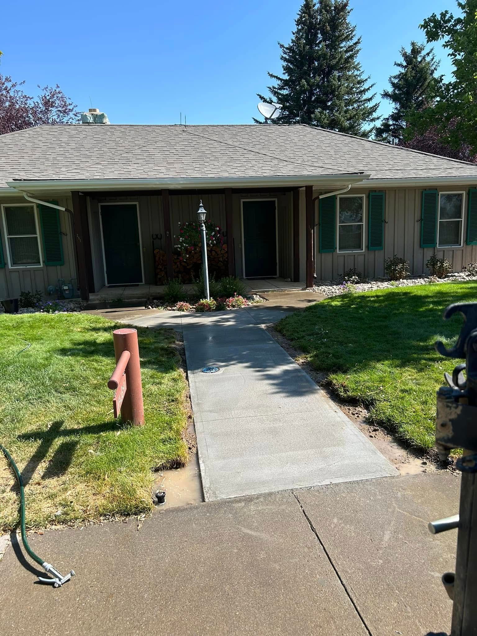 A house with a concrete walkway leading to it and a fire hydrant in front of it.