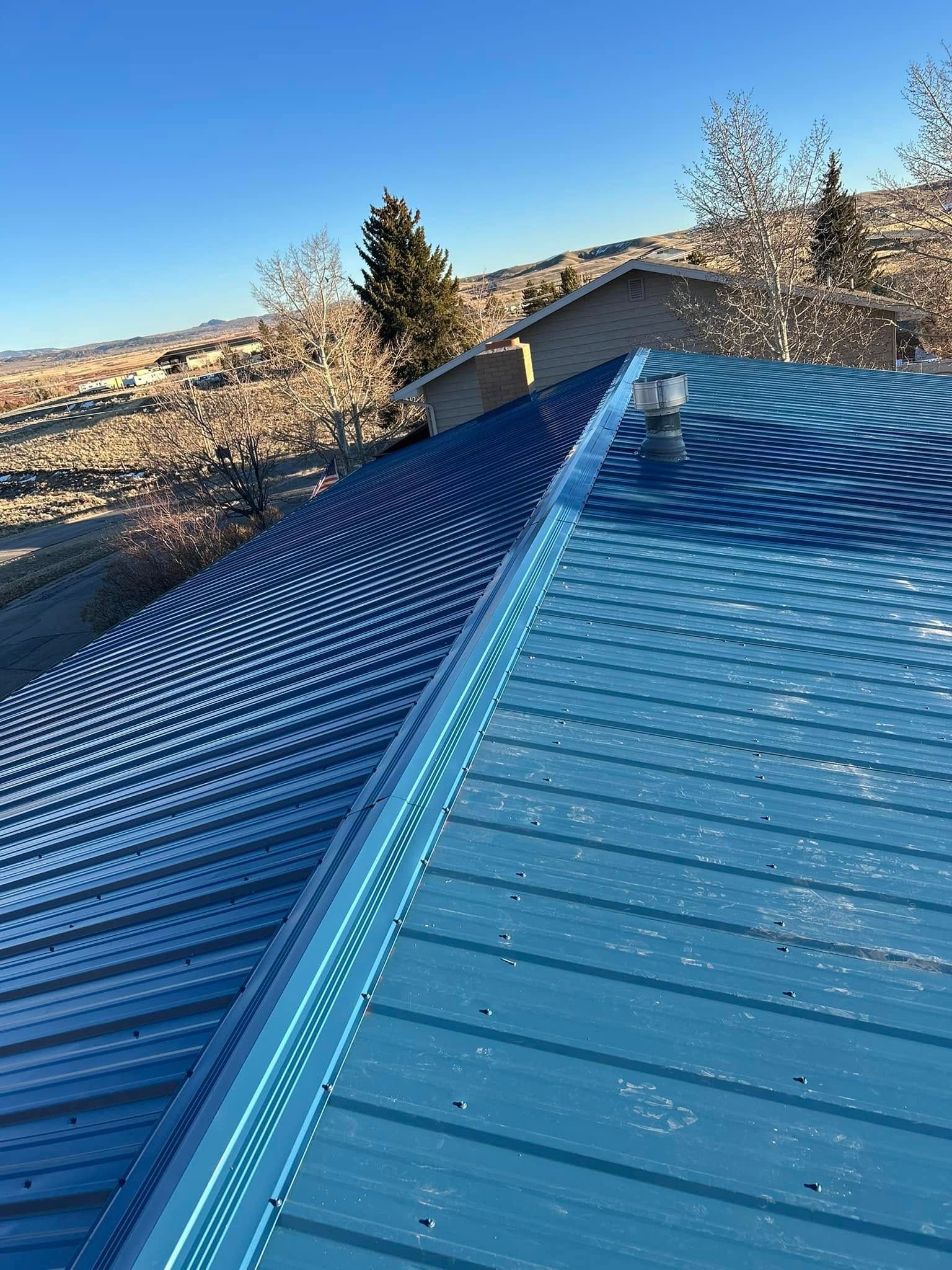 A close up of a blue roof with a blue sky in the background.