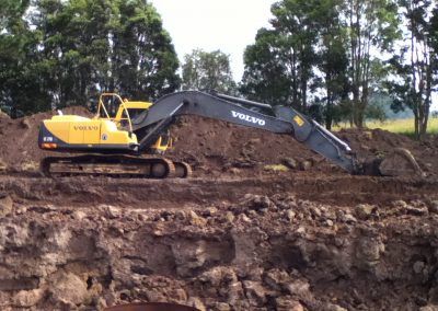 A volvo excavator is digging a hole in the dirt.