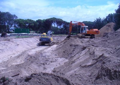 Two excavators are working in a pile of dirt