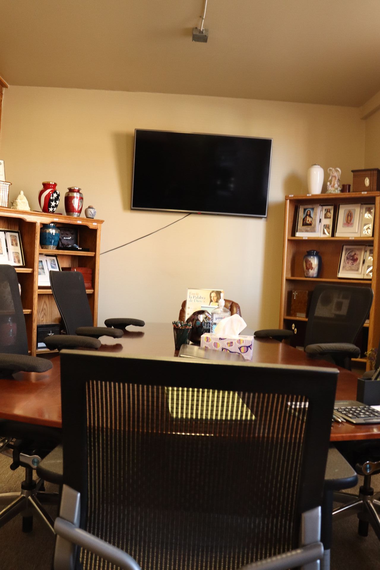 A conference room with a table and chairs and a flat screen tv