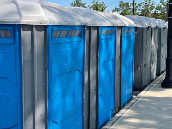 Plastic portable toilets in a row on a side walk