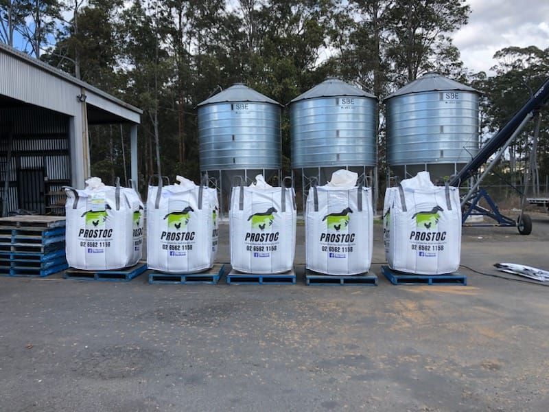 Five Large Bags of Animal Feed on Pallets in Front of Storage Silos — Prostoc In South Kempsey, NSW