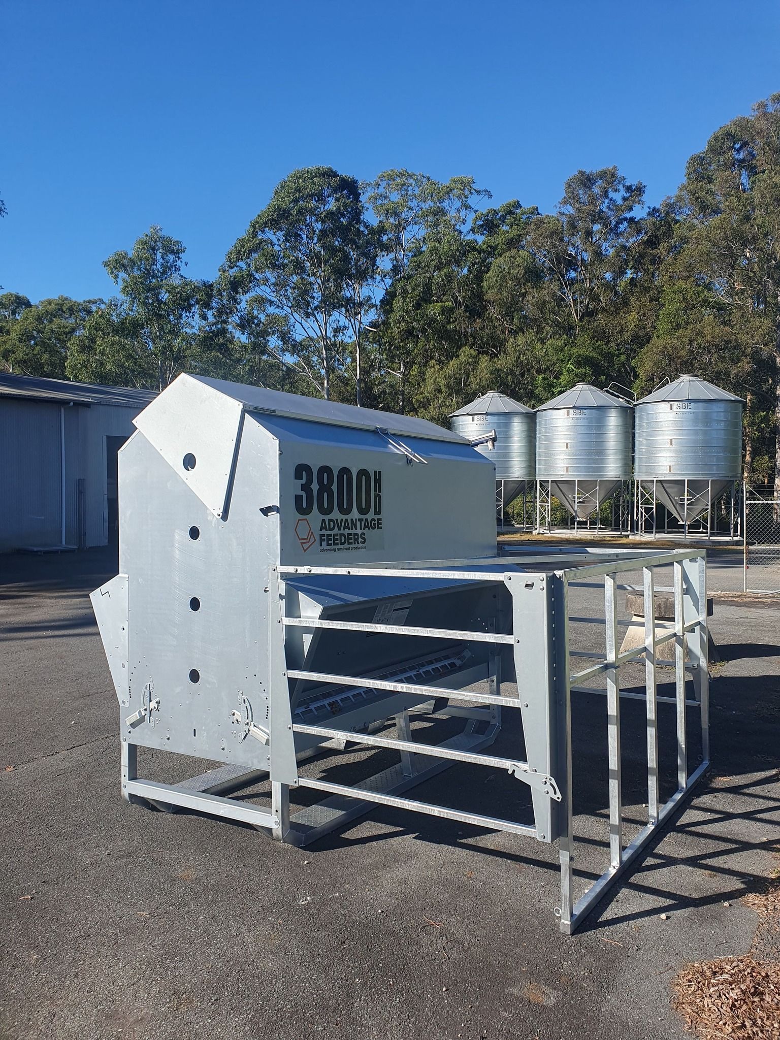 Metal Livestock Feeder in a Gravel Lot With Grain Silos — Prostoc In South Kempsey, NSW