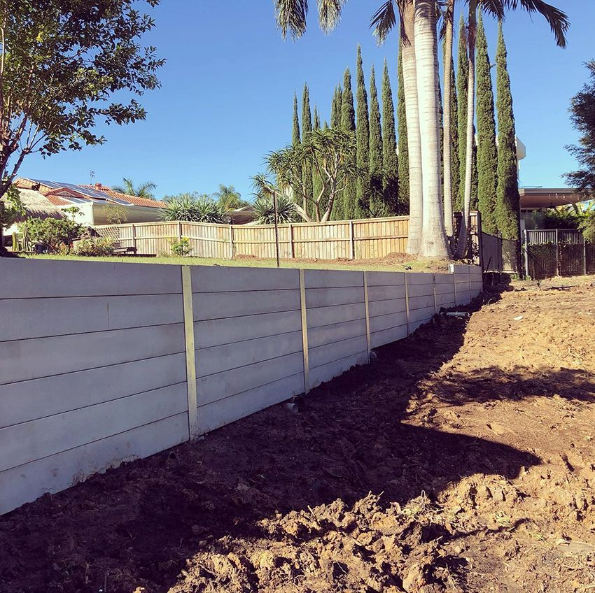 A White Fence Surrounds a Dirt Field with Palm Trees — HMJ Landscapes in Palm Beach, QLD