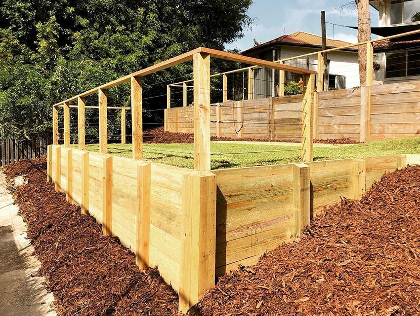 A Wooden Fence is Surrounding a Lush Green Field — HMJ Landscapes in Hope Island, QLD