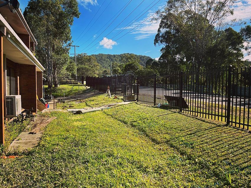 A Fence Surrounds a Lush Green Field — HMJ Landscapes in Burleigh Heads, QLD