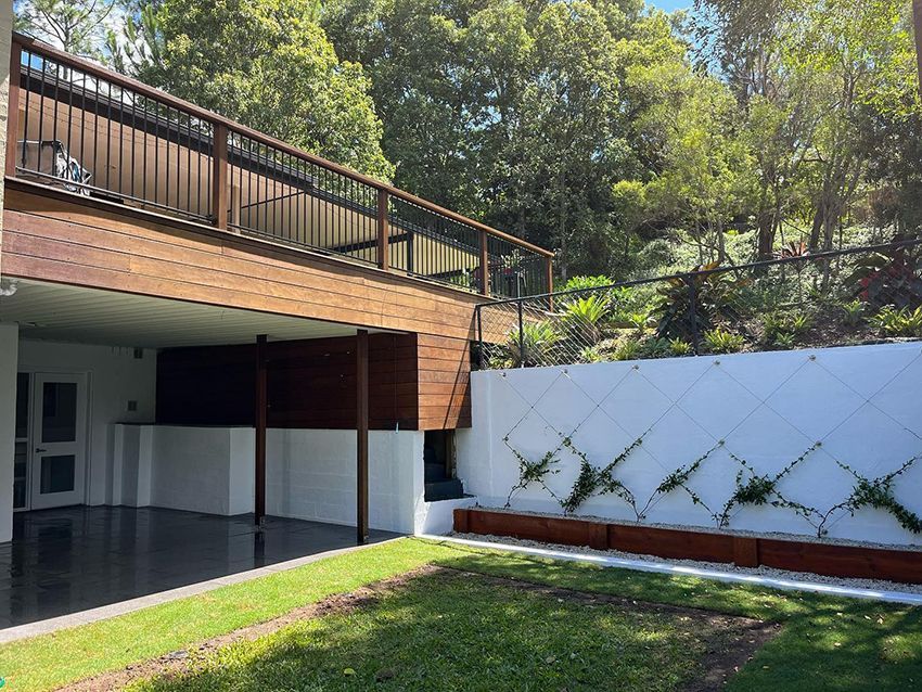A House with a Wooden Deck and a White Wall — HMJ Landscapes in Broadbeach, QLD