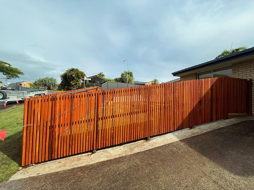 A Wooden Fence is Sitting in Front of a House — HMJ Landscapes in Broadbeach, QLD